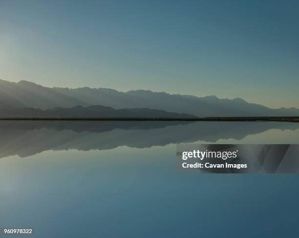 symmetry view of mono lake by mountains against clear sky during sunset - monosjön bildbanksfoton och bilder