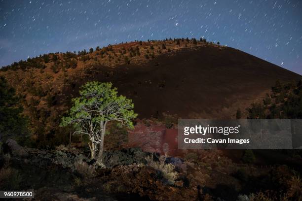 scenic view of mountain against star trails at sunset crater volcano national monument - flagstaff arizona stockfoto's en -beelden