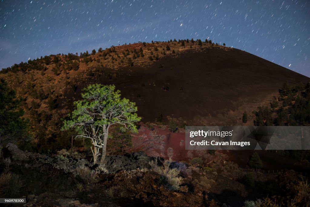 Scenic view of mountain against star trails at Sunset Crater Volcano National Monument