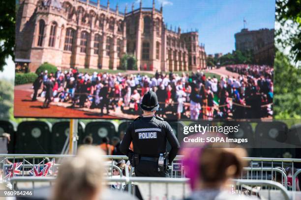 Policeman seen watching the Royal Wedding via a large screen in Windsor. The wedding of Prince Harry and Meghan Markle was held on 19 May 2018 in St...