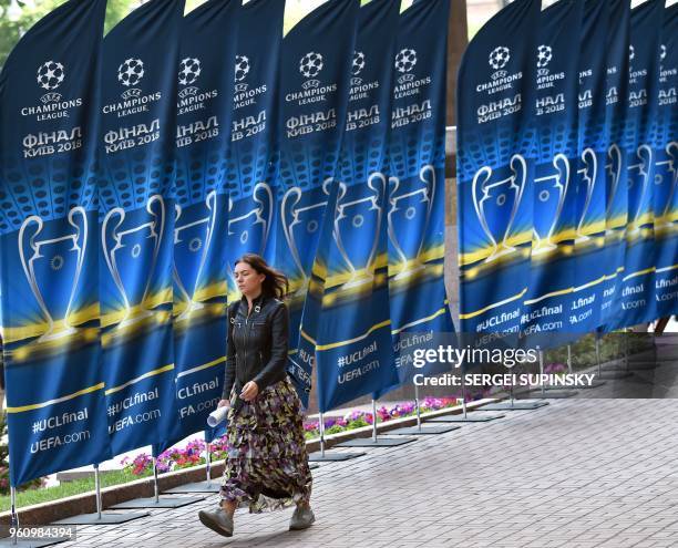 Girl walks past flags with the logo of the 2018 UEFA Champions League Final on May 21, 2018 in Kiev, ahead of the football match between Real Madrid...