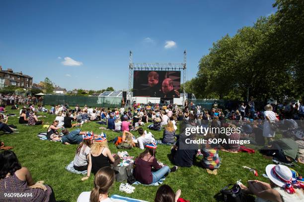 People seen watching the wedding on a large screen in Windsor. The wedding of Prince Harry and Meghan Markle was held on 19 May 2018 in St George's...