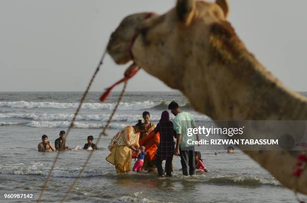 Pakistani residents cool off at Clifton beach during a heat wave in Karachi on May 21, 2018. - Residents of Pakistan's largest city Karachi were...