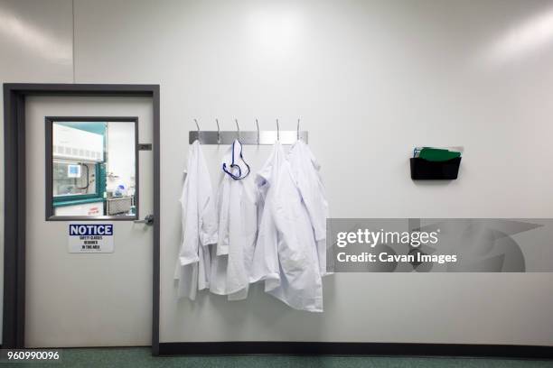 lab coats on hanger - clean suit stock pictures, royalty-free photos & images