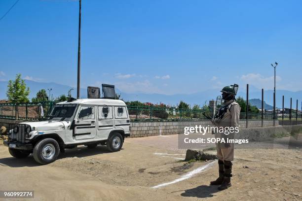 An Indian policeman stands guard near the martyr's graveyard during restrictions imposed ahead of a march to the martyrs graveyard called by the...