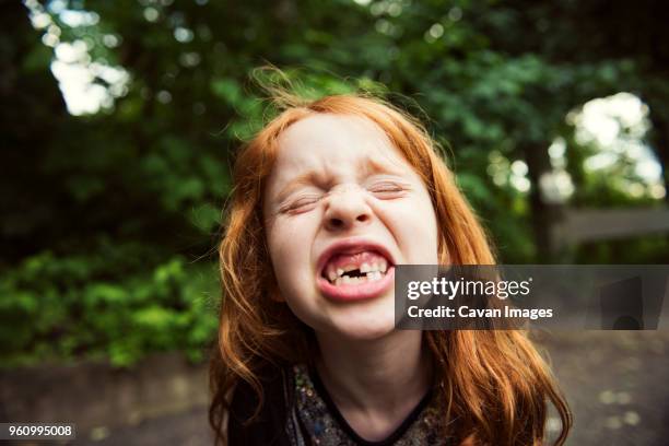 close-up of girl clenching teeth at park - parklücke stock-fotos und bilder