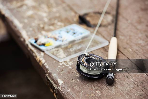 close-up of fishing rod and hooks on wooden table outdoors - fishing tackle box stock pictures, royalty-free photos & images