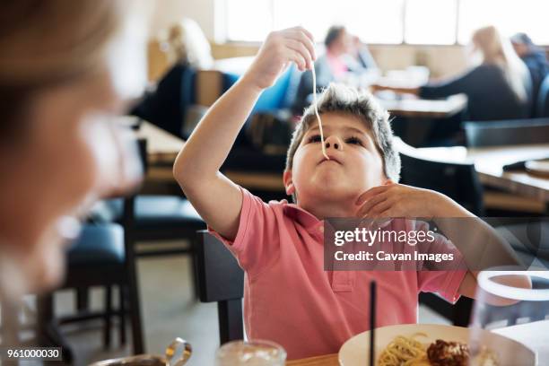 cute boy eating noodle at restaurant table - antic cafe stock pictures, royalty-free photos & images