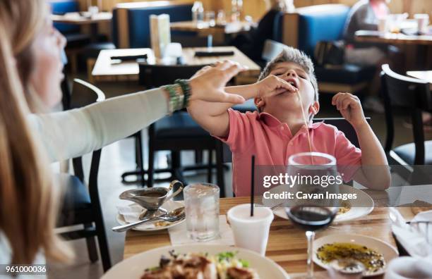 mother stopping son eating noodles in restaurant - antic cafe stock pictures, royalty-free photos & images