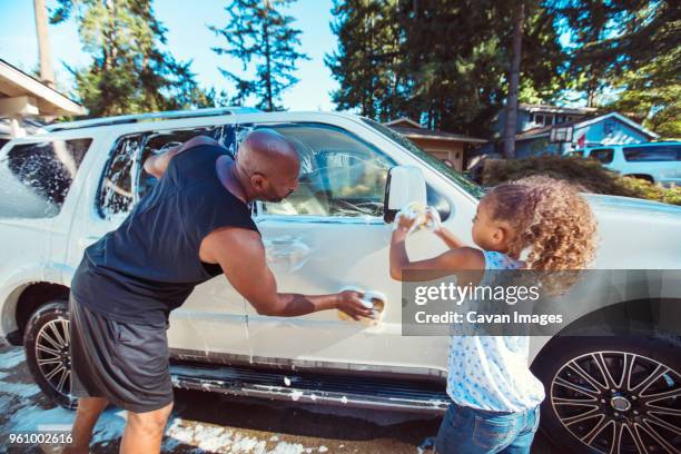 father and daughter washing car in driveway - washing curly hair stock pictures, royalty-free photos & images