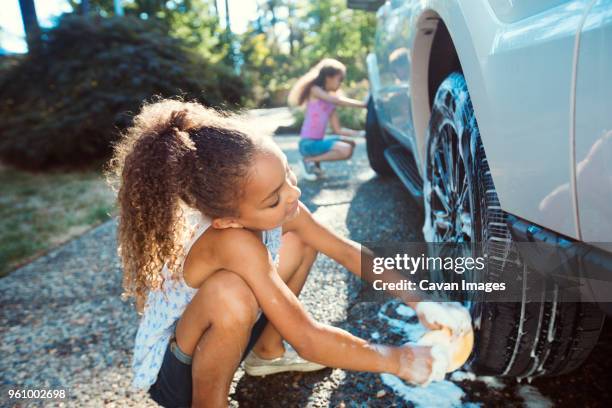 girls washing car in driveway - girl wet casual clothing stock pictures, royalty-free photos & images