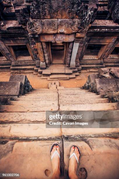 low section of woman standing on steps at angkor wat temple - camboya fotografías e imágenes de stock