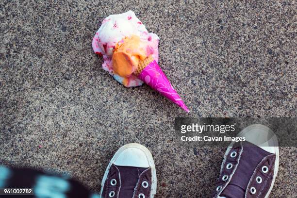 high angle view of ice cream fallen on footpath - low section stockfoto's en -beelden