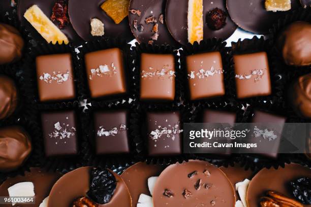 overhead view of various chocolates at factory - fábrica de chocolate fotografías e imágenes de stock
