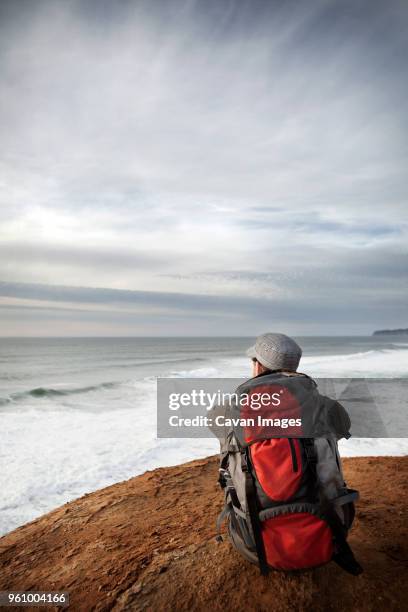 man sitting on edge of cliff - sitting on edge of cliff stock pictures, royalty-free photos & images