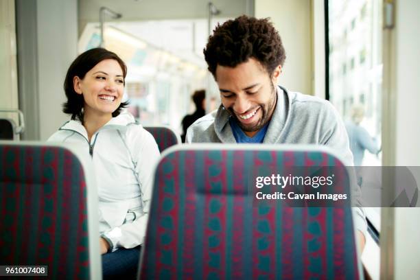 happy multi-ethnic couple travelling in bus - fahrzeugschein stock-fotos und bilder