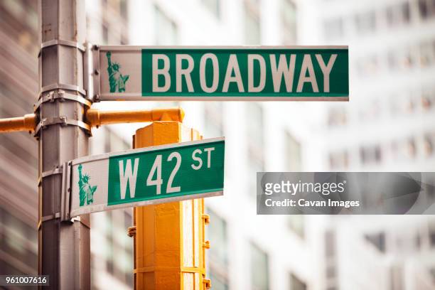 low angle view of road sign in city - broadway stock pictures, royalty-free photos & images