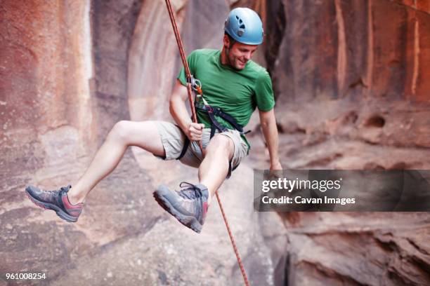 man rappelling down from mountain - abseiling stock pictures, royalty-free photos & images