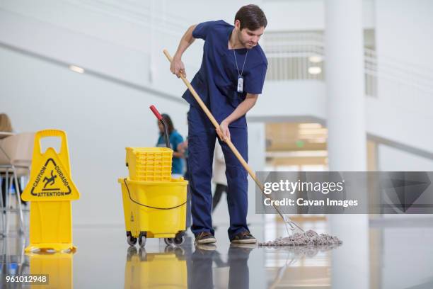 male worker cleaning hospital floor - sweeping stock-fotos und bilder