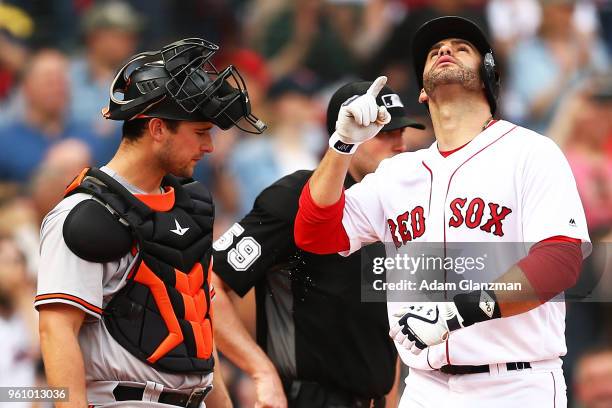 Andrew Susac of the Baltimore Orioles looks on as J.D. Martinez of the Boston Red Sox reacts as he crosses home plate after hitting a two-run home...