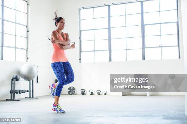 female athlete exercising with jumping rope in gym - springtouw stockfoto's en -beelden