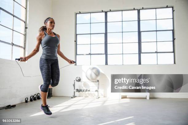 female athlete skipping with jumping rope in gym - skipper stock pictures, royalty-free photos & images