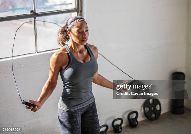 high angle view of female athlete skipping with jumping rope in gym - seilspringen stock-fotos und bilder