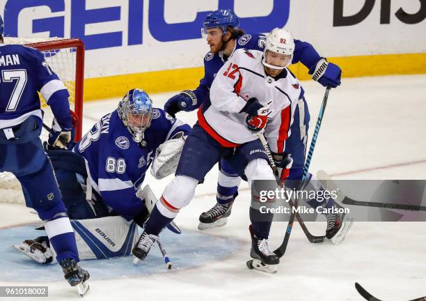 Evgeny Kuznetsov of the Washington Capitals is defended by Brayden Point of the Tampa Bay Lightning in front of Andrei Vasilevskiy during the third...