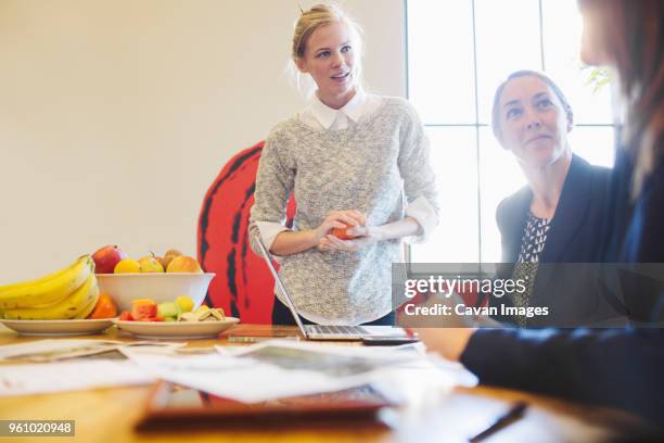 businesswomen discussing at table in office - fruit bowl stock pictures, royalty-free photos & images