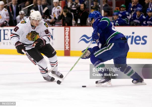 Patrick Kane of the Chicago Blackhawks tries to get past Nolan BaumGartner of the Vancouver Canucks during the first period of NHL action on January...