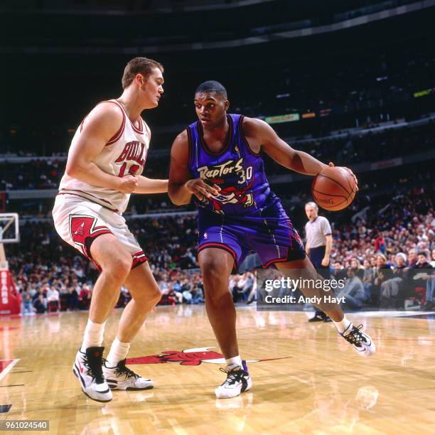 Luc Longley of the Chicago Bulls defends Oliver Miller of the Toronto Raptors on December 22, 1995 at the United Center in Chicago, Illinois. NOTE TO...