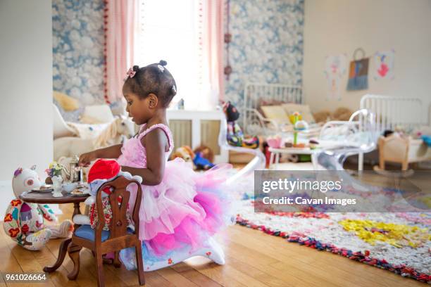 side view of girl in pink dress having a tea party - mini dress photos et images de collection