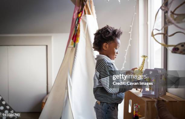 side view of boy playing with animal toys at home - 動物のおもちゃ ストックフォトと画像