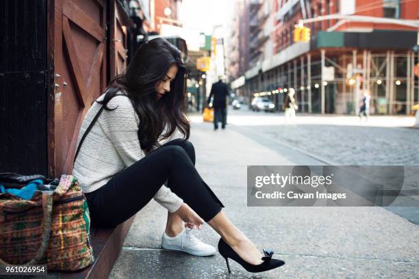 side view of woman wearing canvas shoe on sidewalk - tacchi alti foto e immagini stock