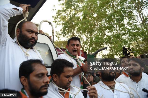 Pareshbhai Dhanani , Congress opposition leader at the Gujarat Legislative Assembly, gestures while holding a fuel pump dispenser during a a protest...