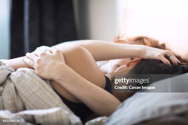 lesbian couple lying on bed at home - lesbian bed stock pictures, royalty-free photos & images