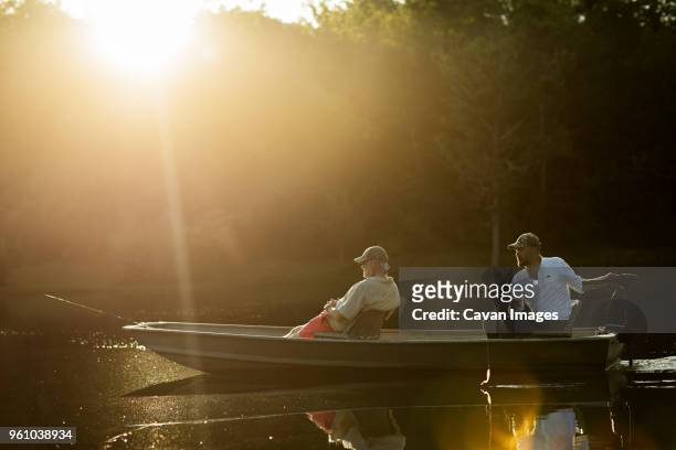 friends sitting in rowboat while fishing at lake - birmingham alabama stock-fotos und bilder