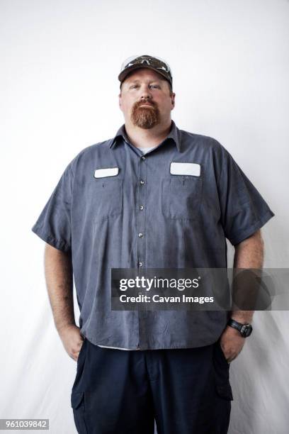 portrait of confident worker standing against white background - chubby men stock pictures, royalty-free photos & images