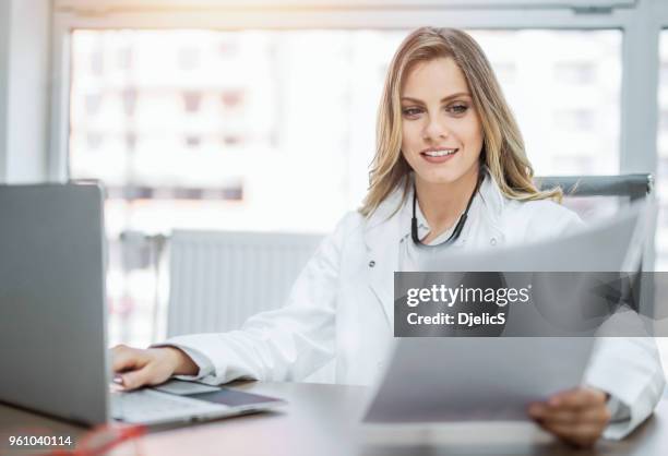 happy young female doctor working in office. - doctor recruitment stock pictures, royalty-free photos & images