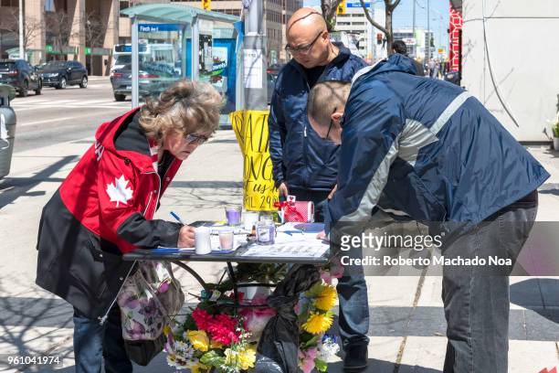 Toronto Van Attack a week later: People signing the condolences book. The woman wears a Canada colours. .Image taken at Olive Park in the...