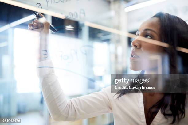 close-up of businesswoman writing with felt tip pen on glass in board room at office - felt tip pen stock-fotos und bilder