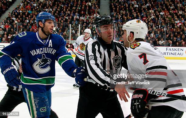 Linesman Thor Nelson steps in to separate Ryan Kesler of the Vancouver Canucks and Brent Seabrook of the Chicago Blackhawks during their game at...