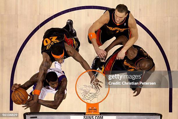 Earl Clark of the Phoenix Suns is fouled as he attempts a shot against Cartier Martin, Andris Biedrins and Anthony Tolliver of the Golden State...