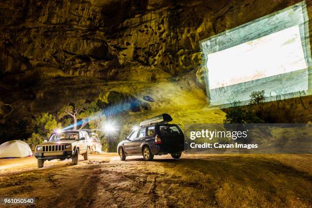 off-road vehicles with projection screen on mountain at campsite - cinema projector stock pictures, royalty-free photos & images