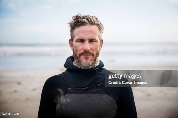 portrait of confident surfer standing at beach - 中年の男性一人 ストックフォトと画像