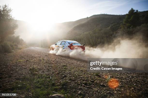 car moving on road against sky on sunny day - dirt track stock-fotos und bilder