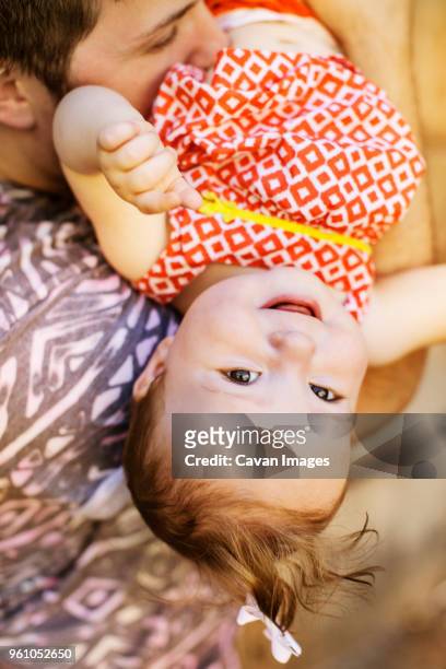 man playing with smiling baby girl - genderblend2015 stock pictures, royalty-free photos & images