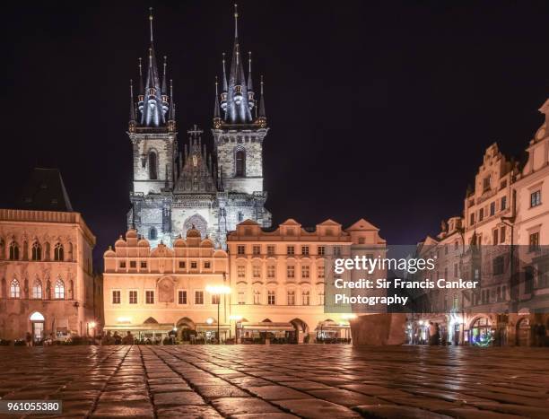 tyn church facade and old town square illuminated at night in prague, czech republic, a unesco heritage site - teynkirche stock-fotos und bilder