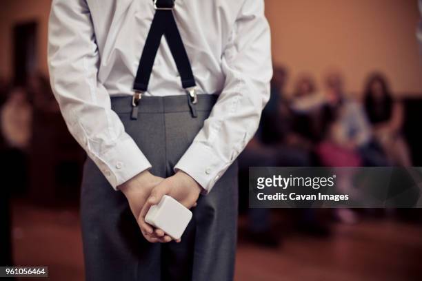 rear view of pageboy holding wedding ring box in ceremony - pageboy stock-fotos und bilder