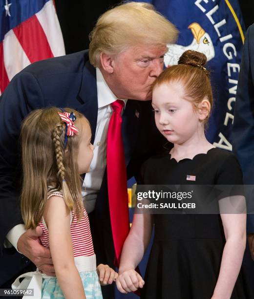 President Donald Trump greets two girls as he attends the swearing-in ceremony for Gina Haspel as Director of the Central Intelligence Agency at CIA...